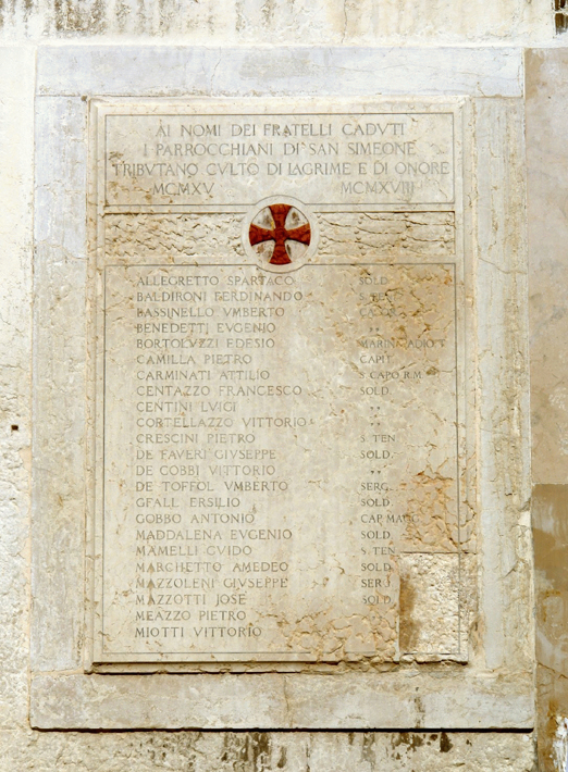 San Simeone Grande lapide commemorativa 1 Lapide commemorativa rettangolare, divisa in due comparti da un fregio animato da motivo decorativo a foglie di alloro a destra, e a foglie di quercia a sinistra; al centro, croce greca inscritta entro un tondo con cornice a listello piatto. La stessa tipologia di cornice si ritrova anche lungo i bordi della lastra.
